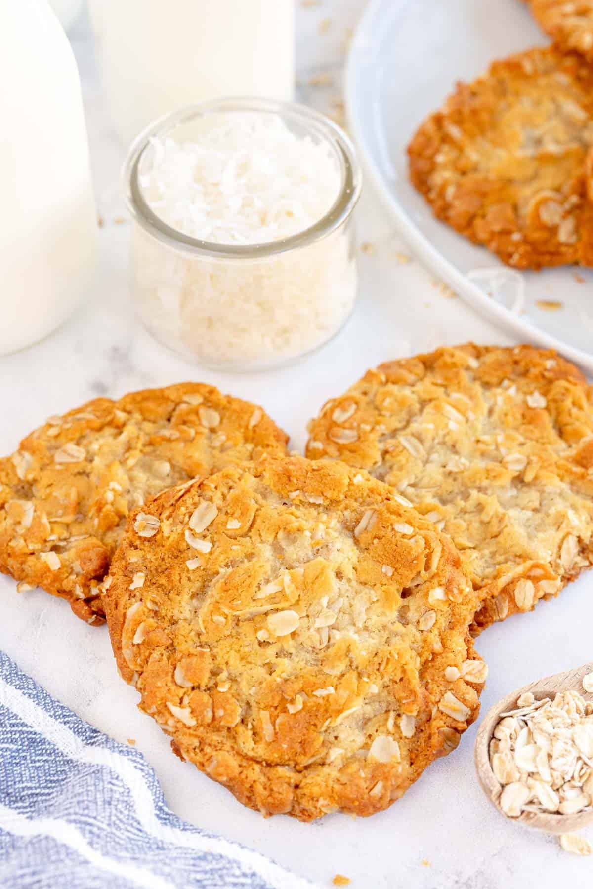 ANZAC cookies with a glass of milk in the background.