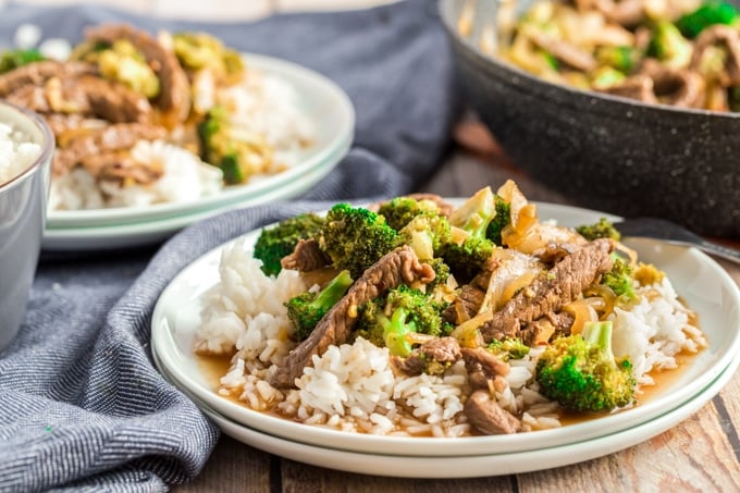 beef and broccoli on a white plate with blue napkins