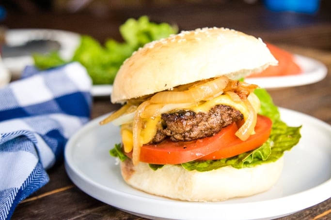 a homemade beef burger on a white plate