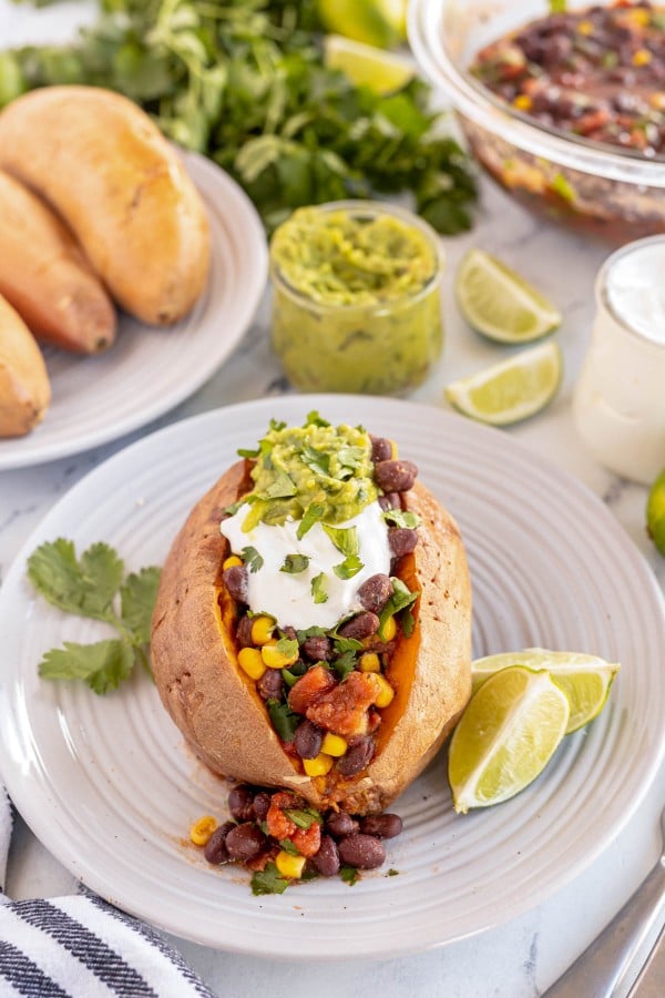 baked sweet potato with black bean salad on a plate.