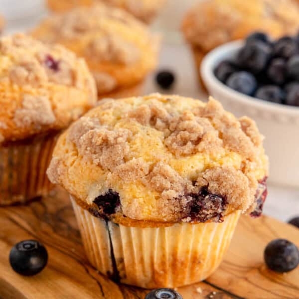 a blueberry muffin on a wooden board.