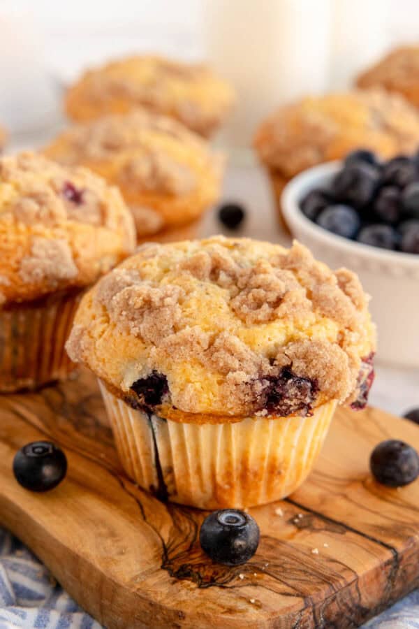 a blueberry muffin on a wooden board.