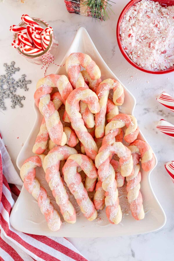 candy cane cookies on a white tree shaped plate