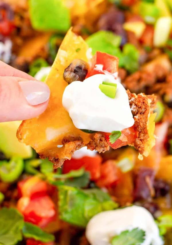 nachos being held by fingers.