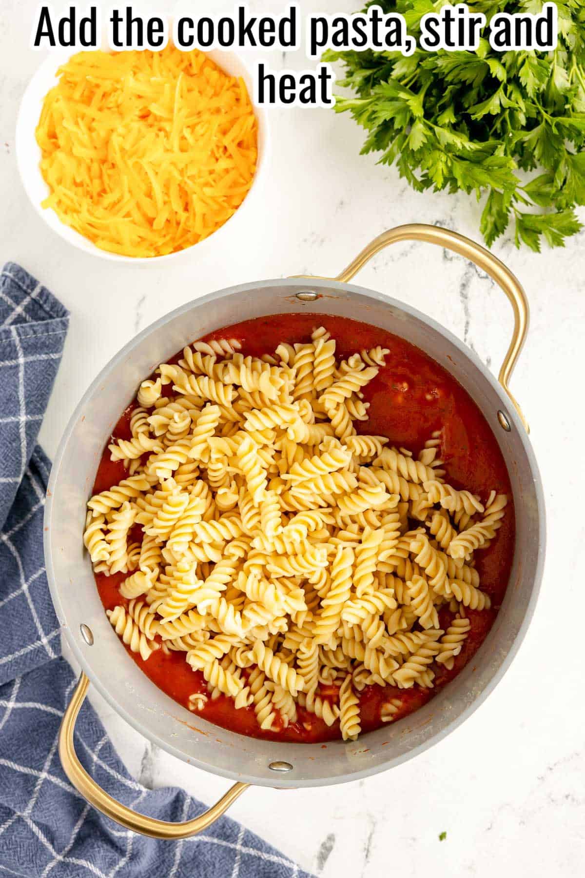 pasta added to a red sauce in a pot.