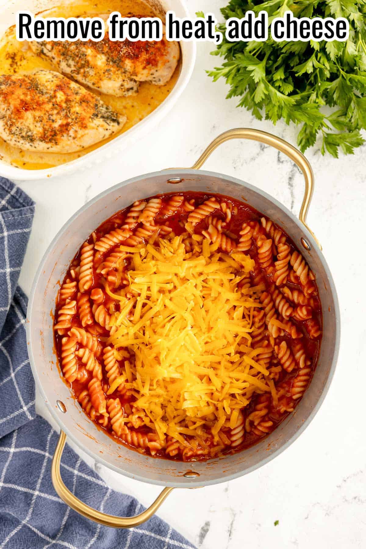 cheese and pasta added to a red sauce in a pot.