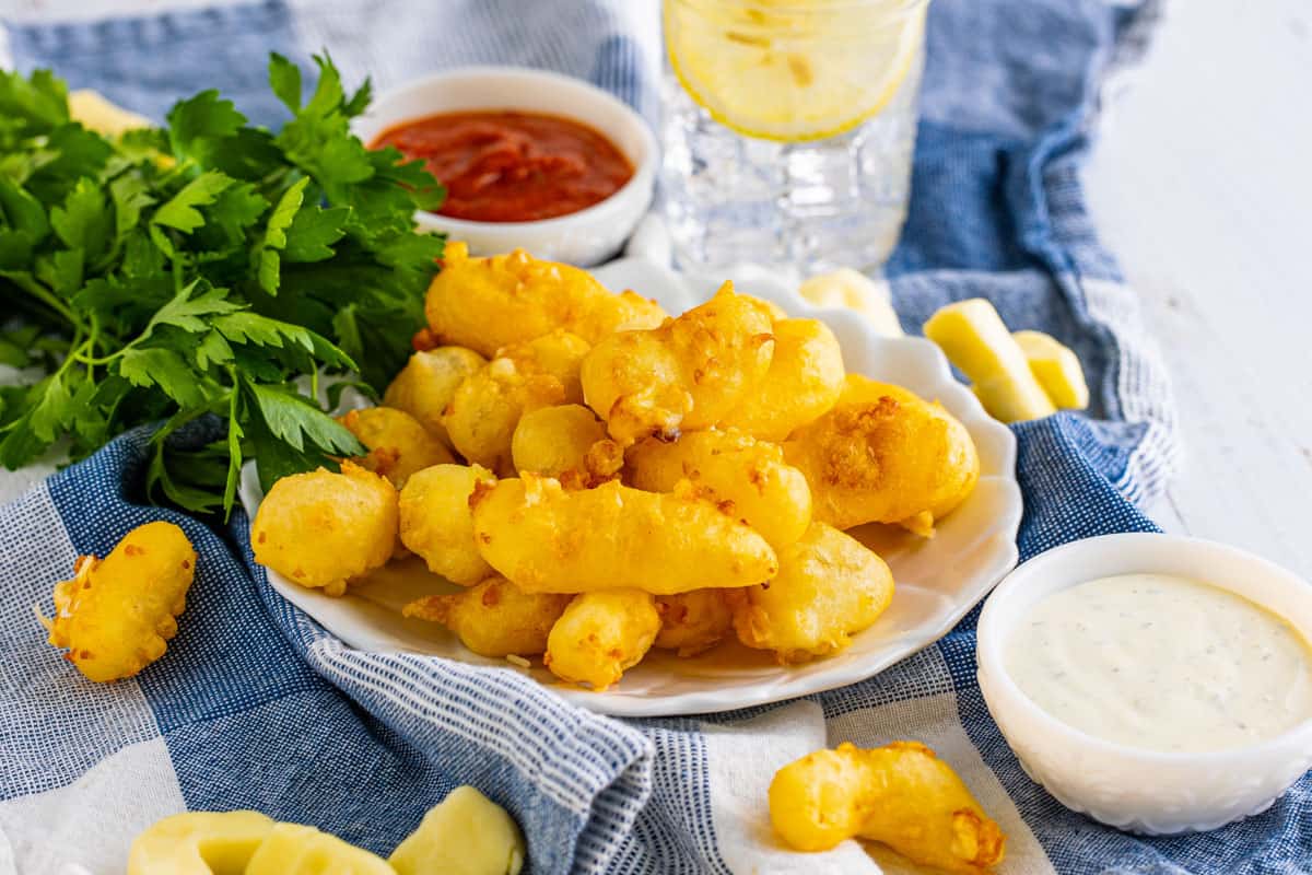 fried cheese curds in a bowl with condiments.