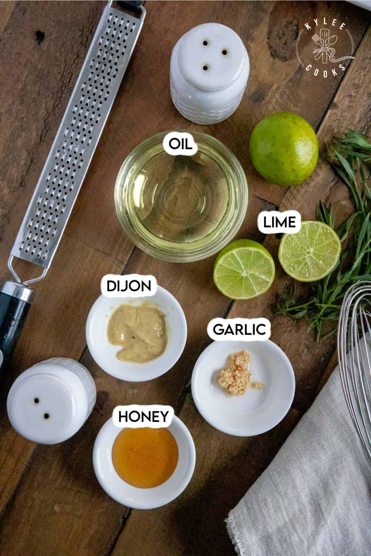 ingredients to make a dressing for grilled veggie salad laid out on a wooden board and labeled.