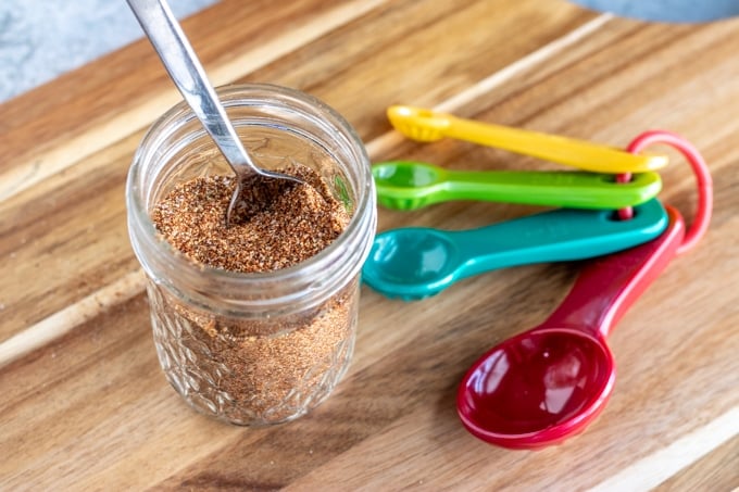taco seasoning in a glass jar with a spoon