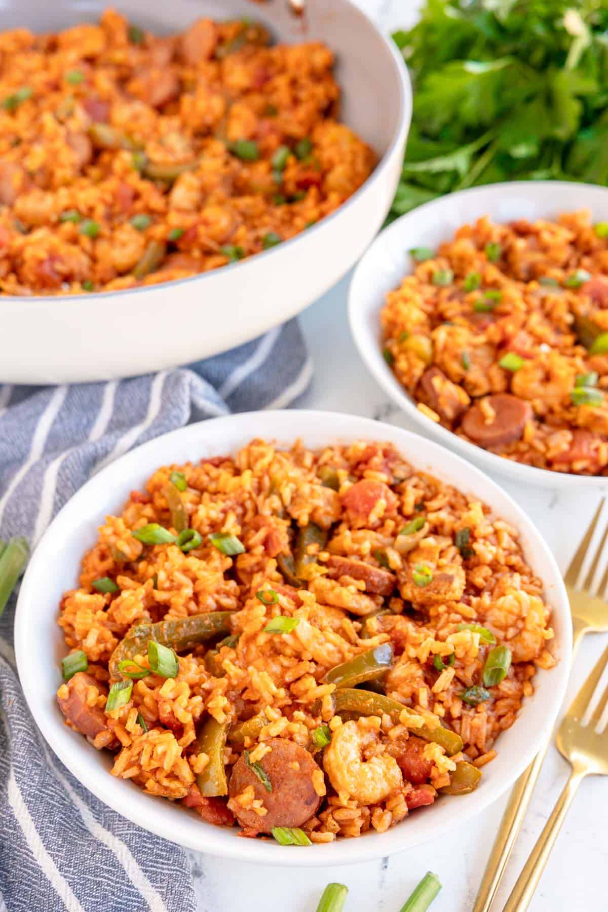 3 bowls of jambalaya with a striped napkin.