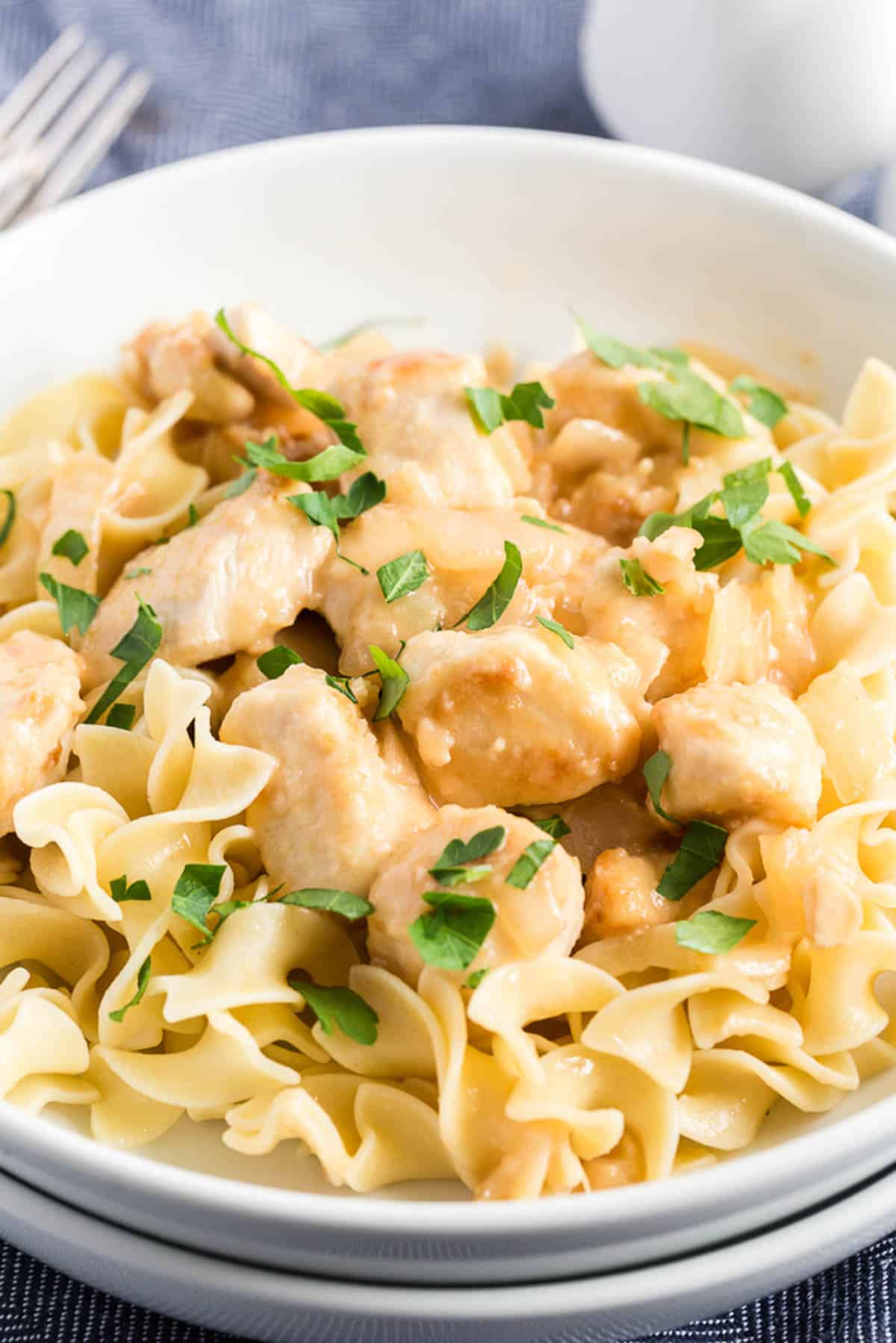 lemon chicken in a white bowl with parsley sprinkled over the top.