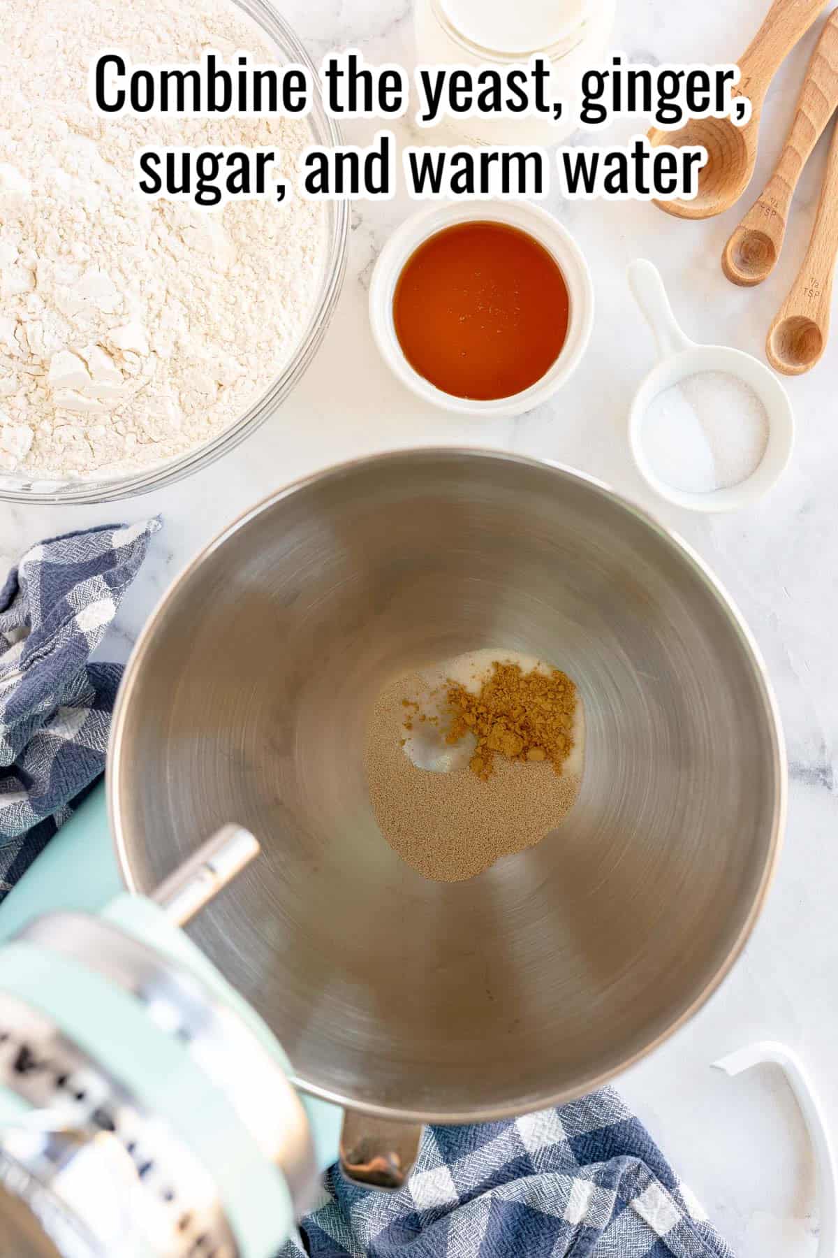 A large mixing bowl contains yeast and ginger, essential for sandwich bread. Next to it are bowls with flour, sugar, water, and measuring spoons. An instruction reading "Combine the yeast, ginger, sugar, and warm water" is at the top.