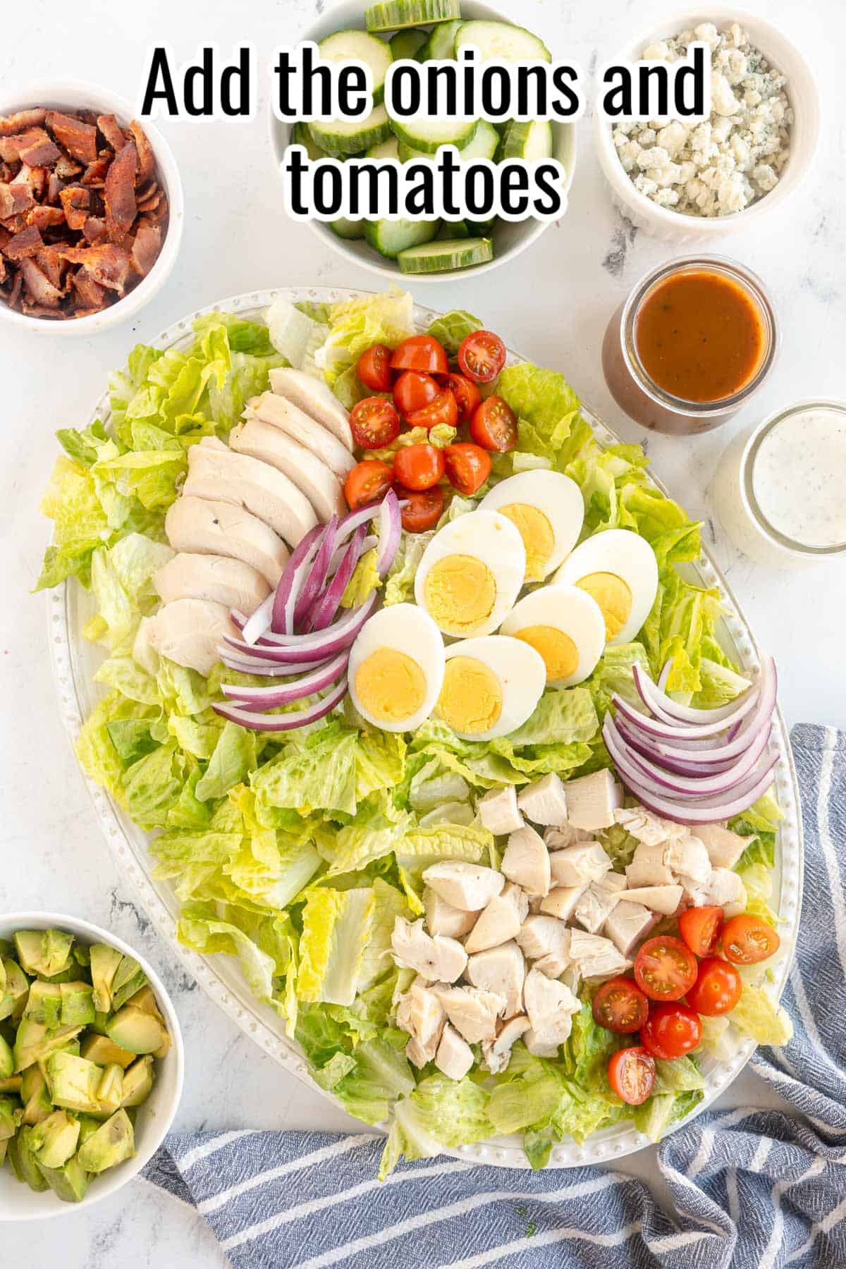 Platter with lettuce, chicken, eggs, tomatoes and onions.