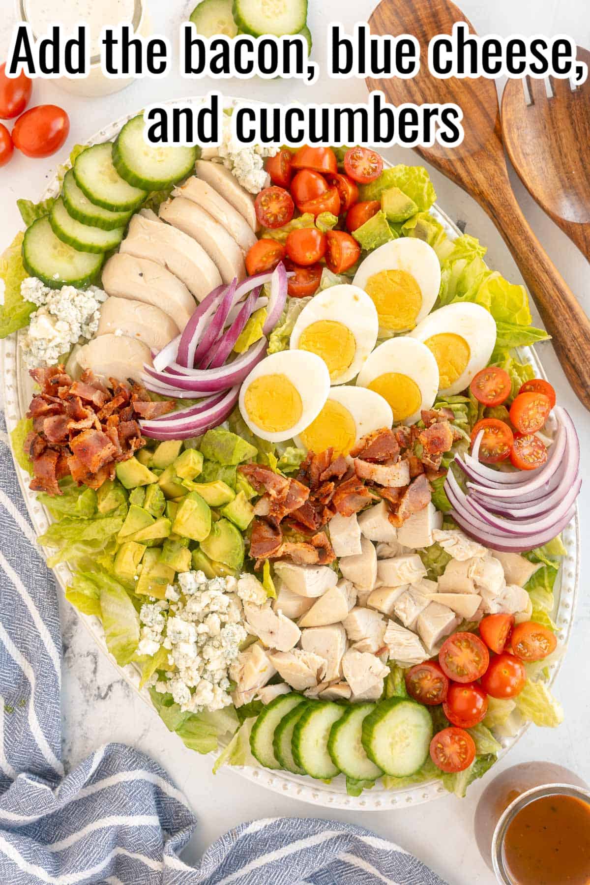 Platter with lettuce, chicken, eggs, tomatoes, onions. bacon and blue cheese.