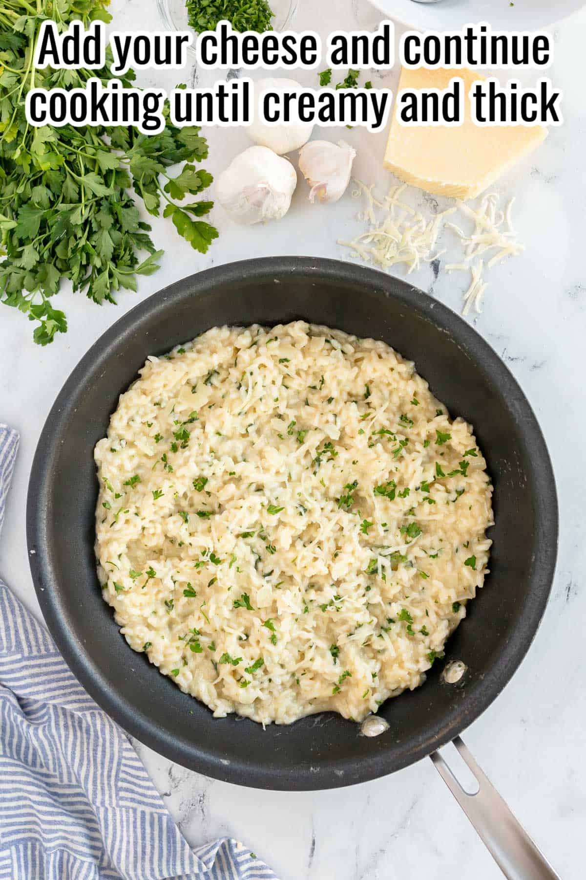 finished risotto in a black skillet, with herbs over the top.