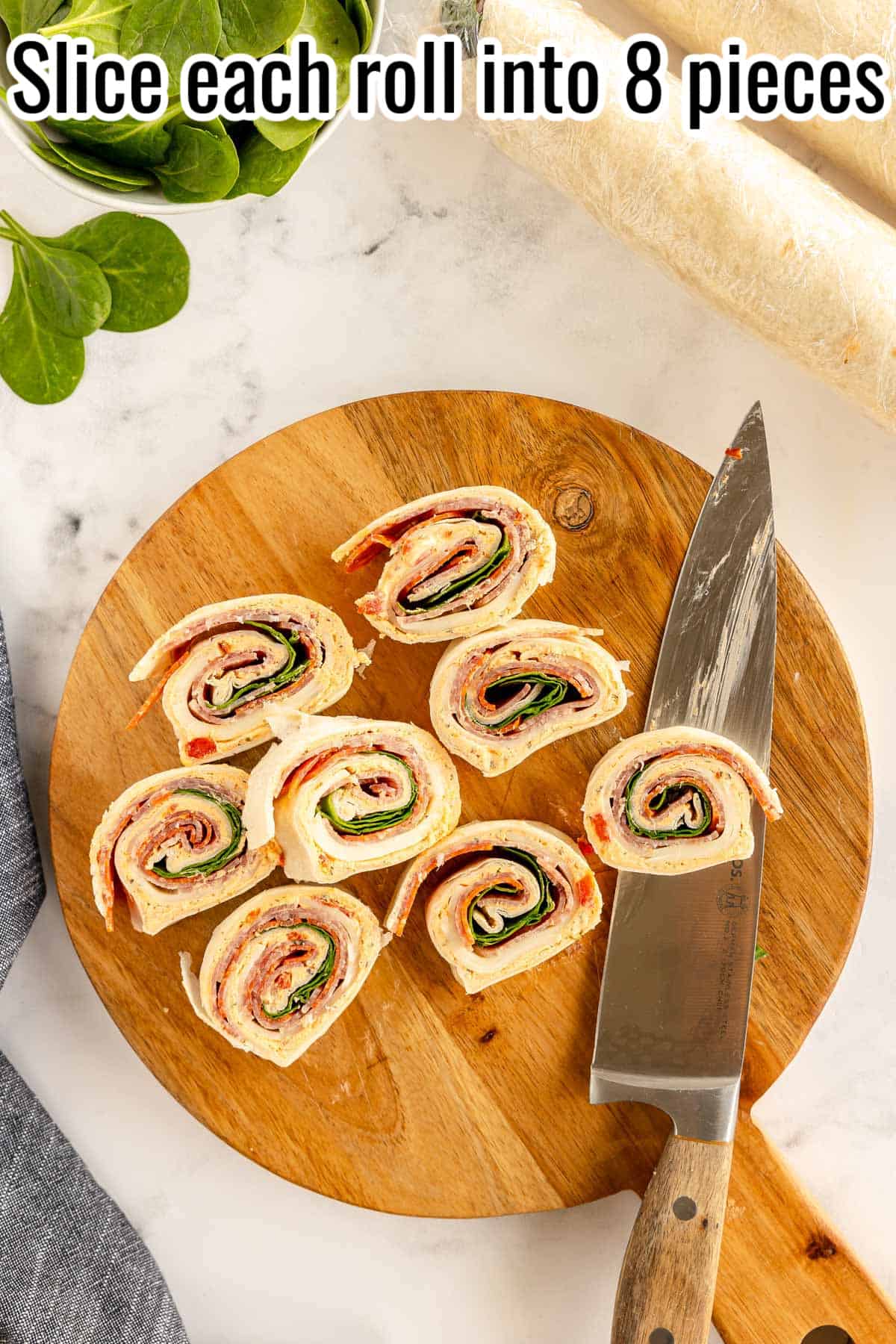 sliced pinwheels on a wooden cutting board.