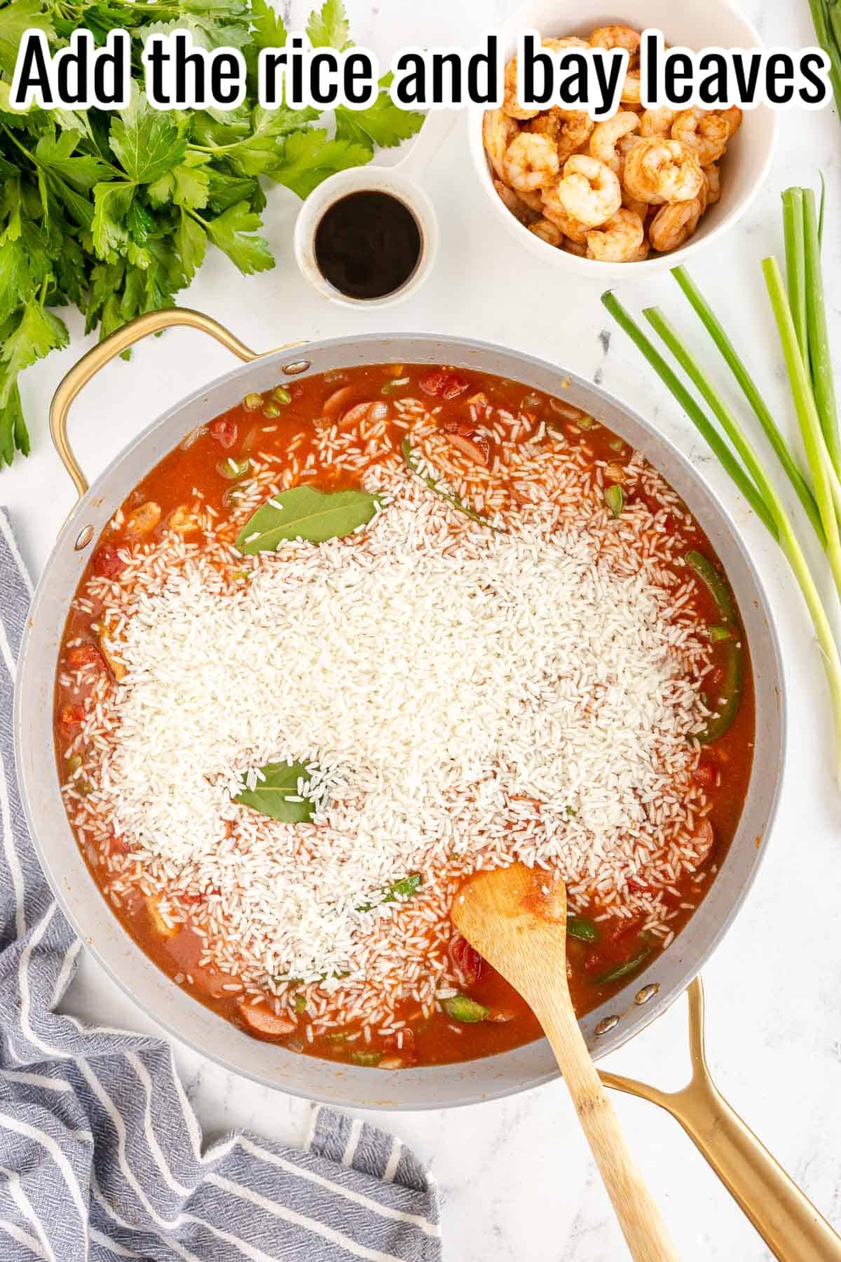 a skillet with rice and bay leaves added.