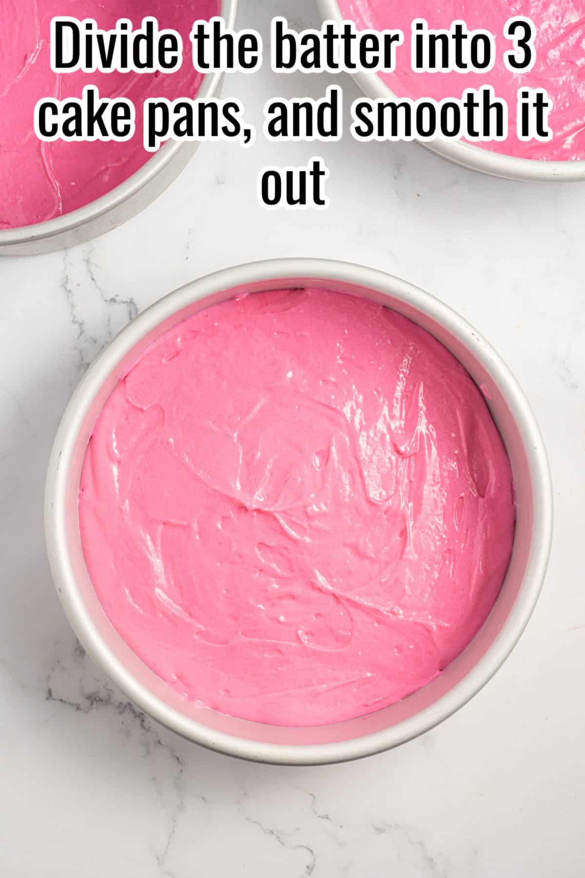 A cake pan with pink cake batter.