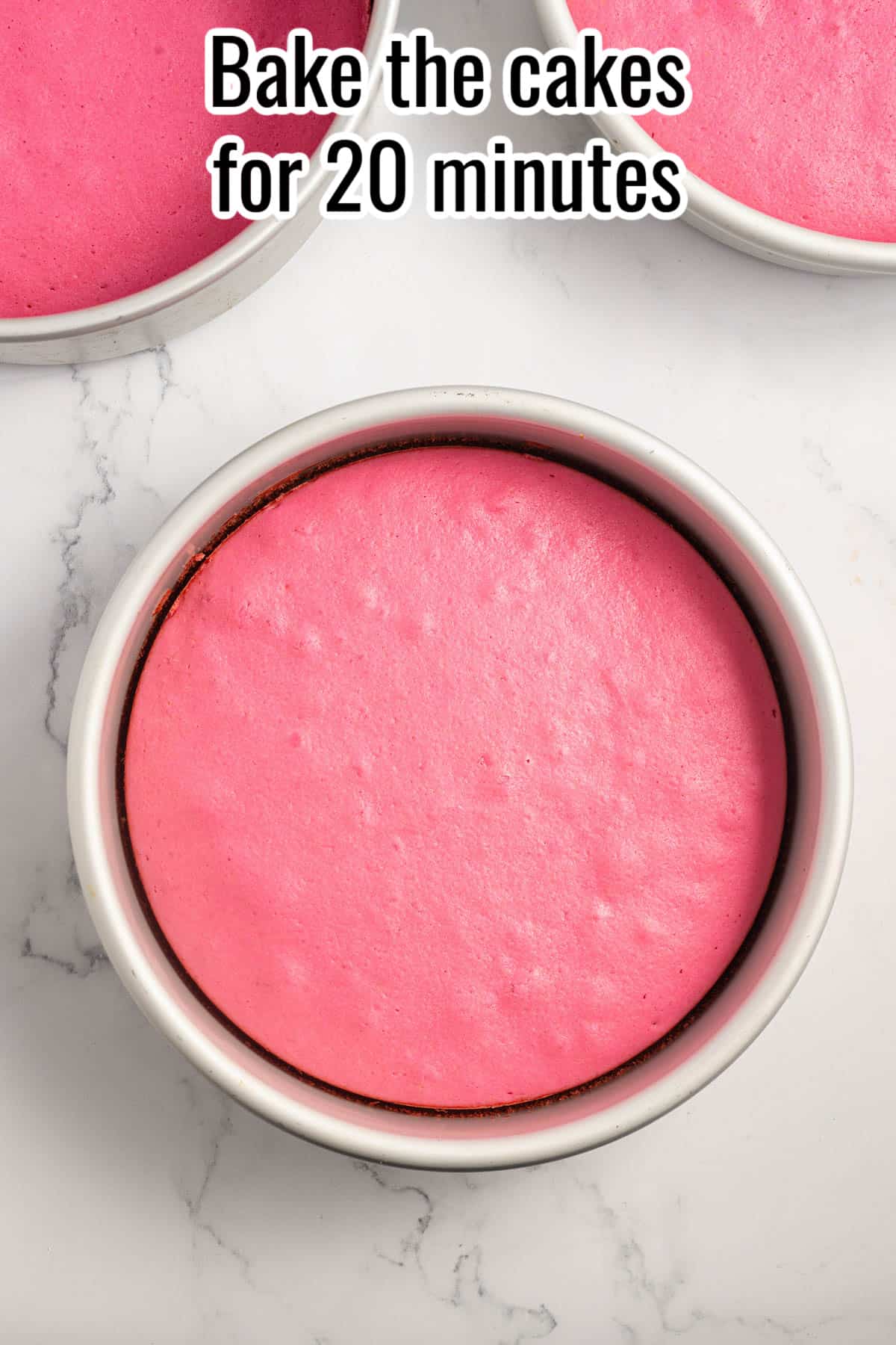 A cake pan with a baked pink cake in it