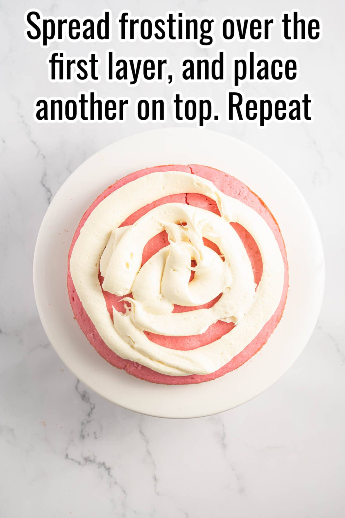 A pink cake with cream cheese frosting piped on top.