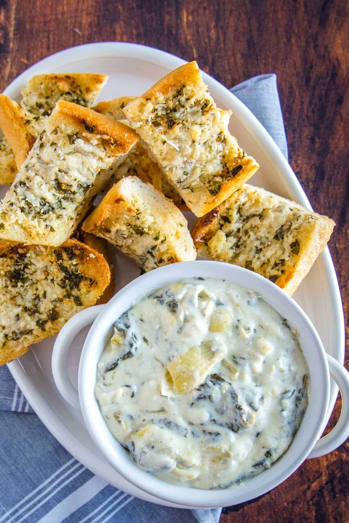 overhead of spinach artichoke dip, on a white platter