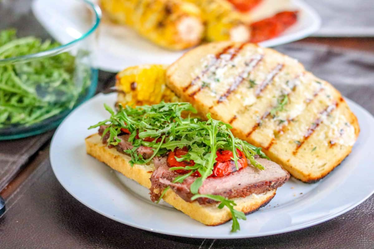 close up of a steak sandwich on a plate.