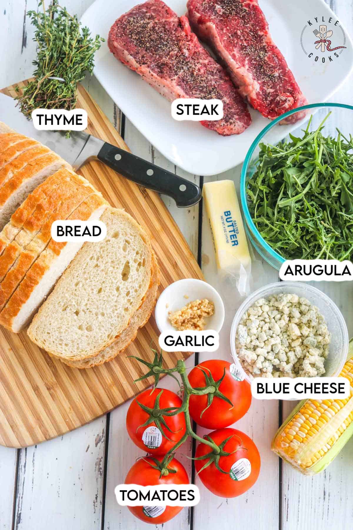 ingredients to make a steak sandwich laid out and labeled.