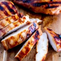 Grilled teriyaki chicken on a chopping board, sliced