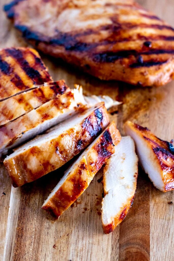 Grilled teriyaki chicken on a chopping board, sliced