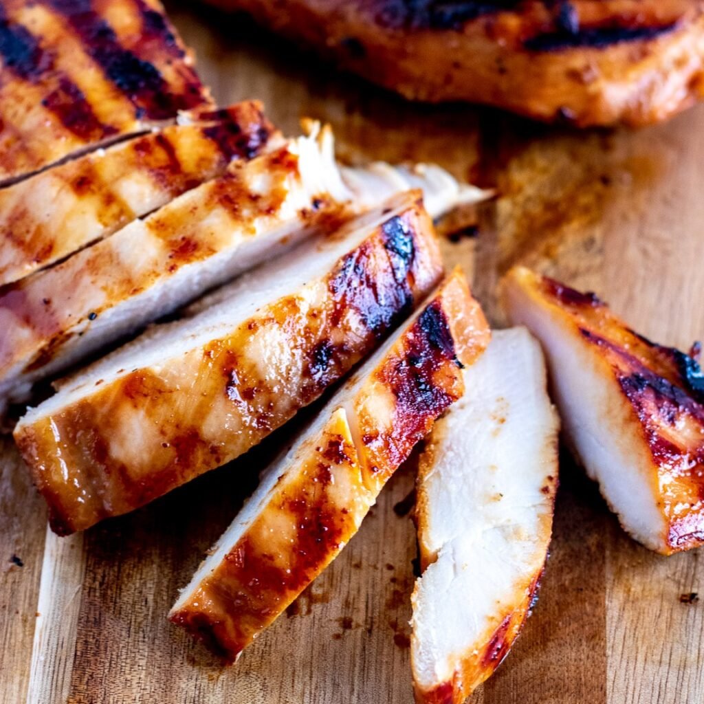 Grilled chicken on a chopping board, sliced